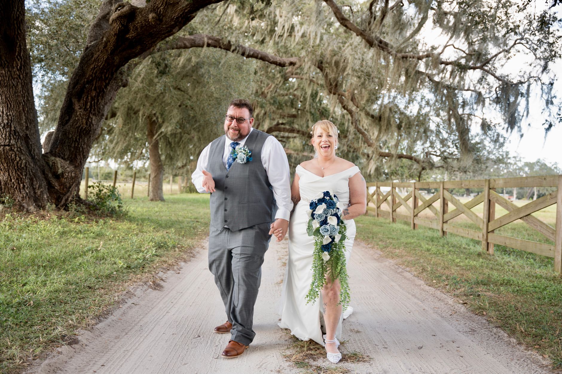 A bride and groom standing beneath moss-draped oak trees at Middleton Place in Charleston, South Carolina