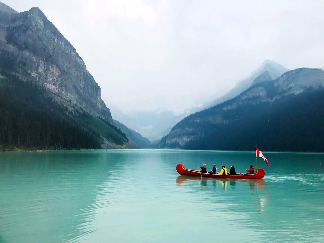 A canoe crosses Lake Louise below the Fairmont Chateau's boathouse.