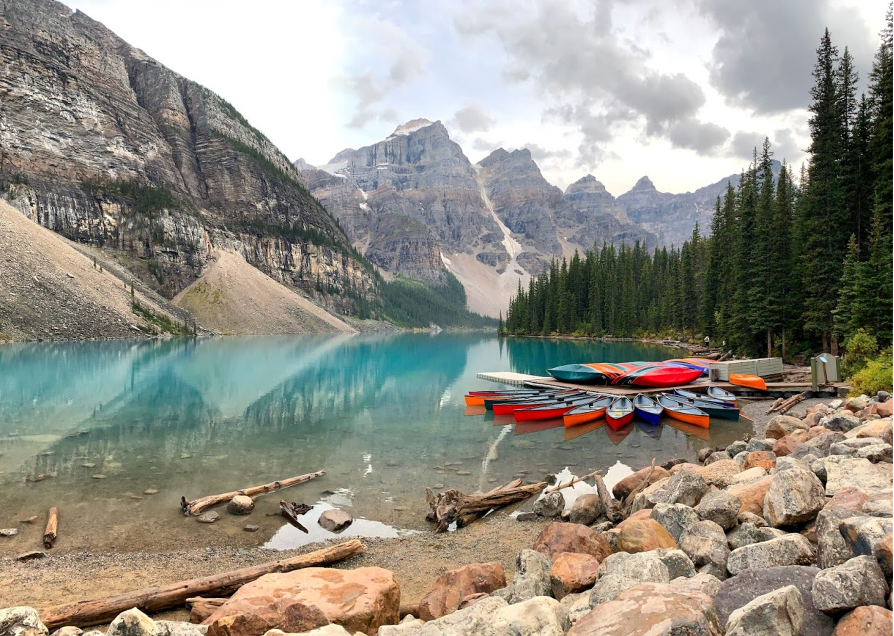 A canoe pulled up on the shore of Moraine Lake in the early morning quiet.
