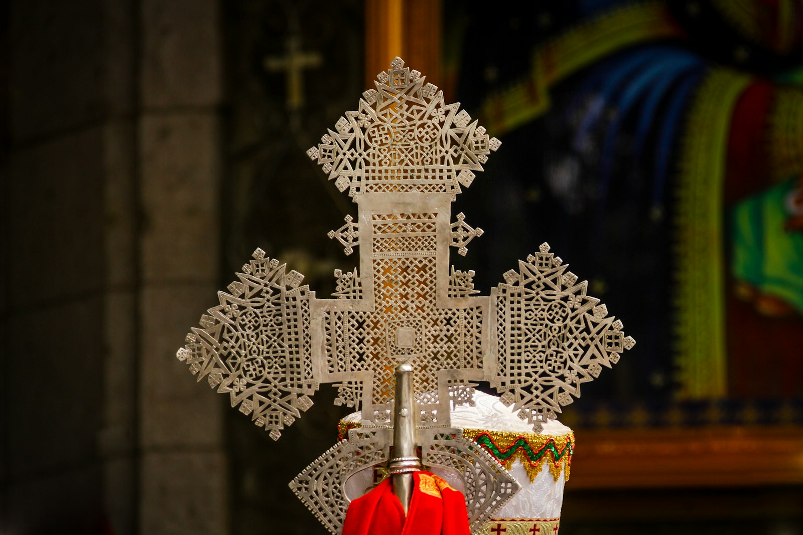 A priest at Bete Giyorgis holding a brass processional cross carried in Timkat processions.