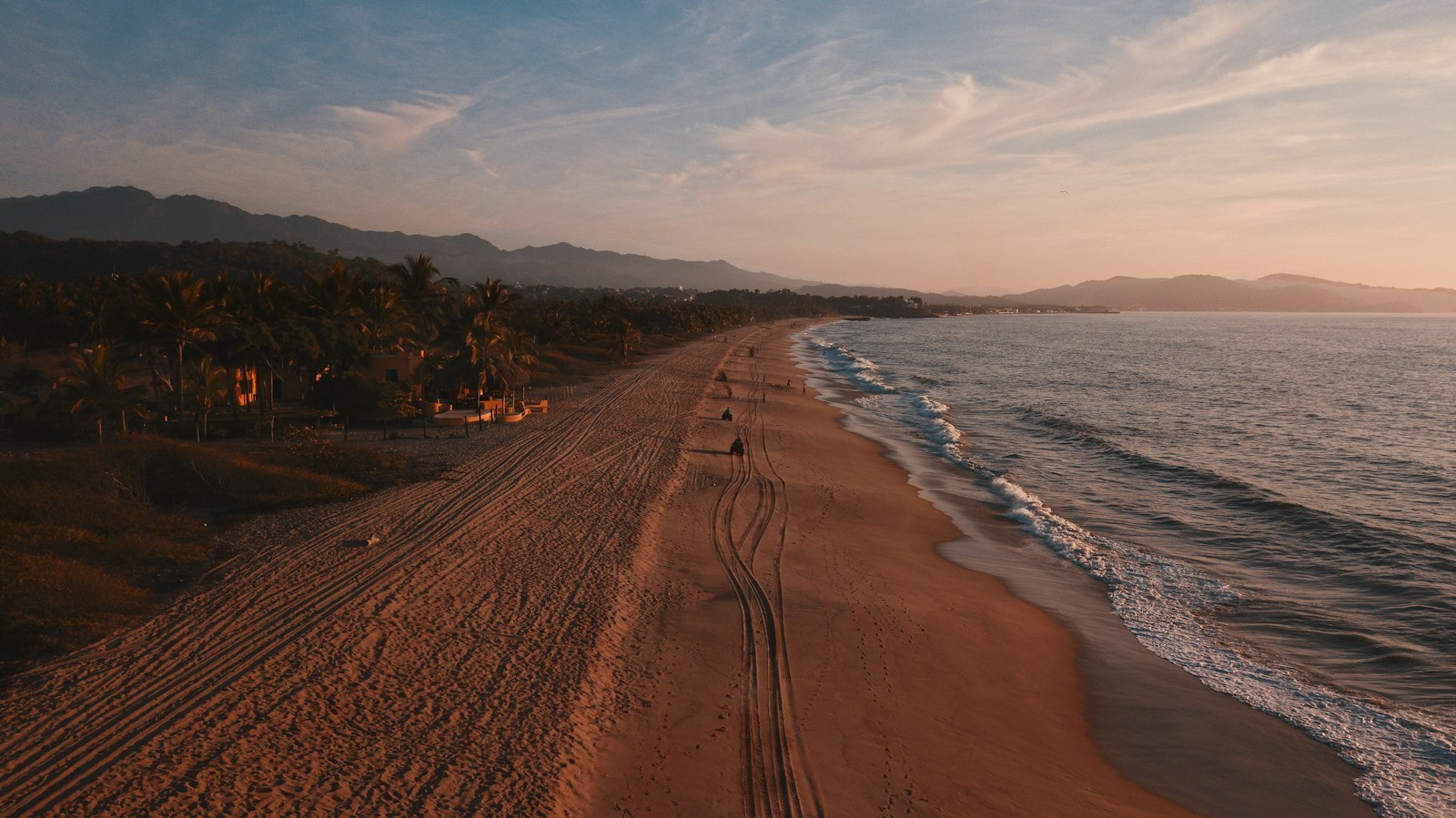 Aerial view of a turquoise bay lined with palm trees at Punta de Mita, Mexico