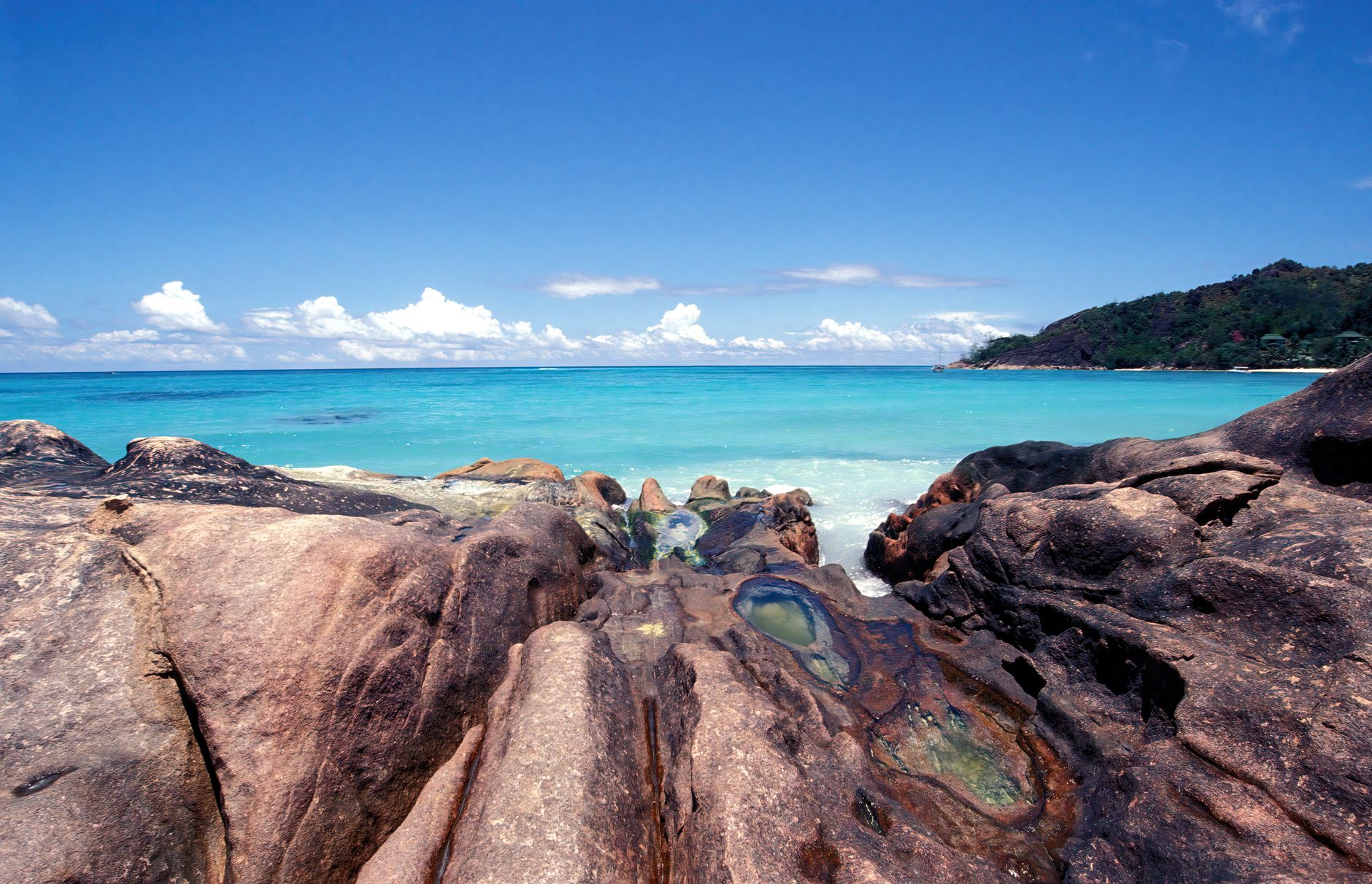 Aerial view of North Island, Seychelles, showing granite boulders and a curved white-sand beach