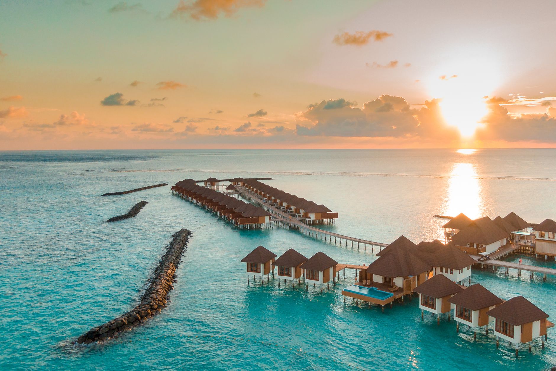 Aerial view of overwater villas in the Maldives at sunset