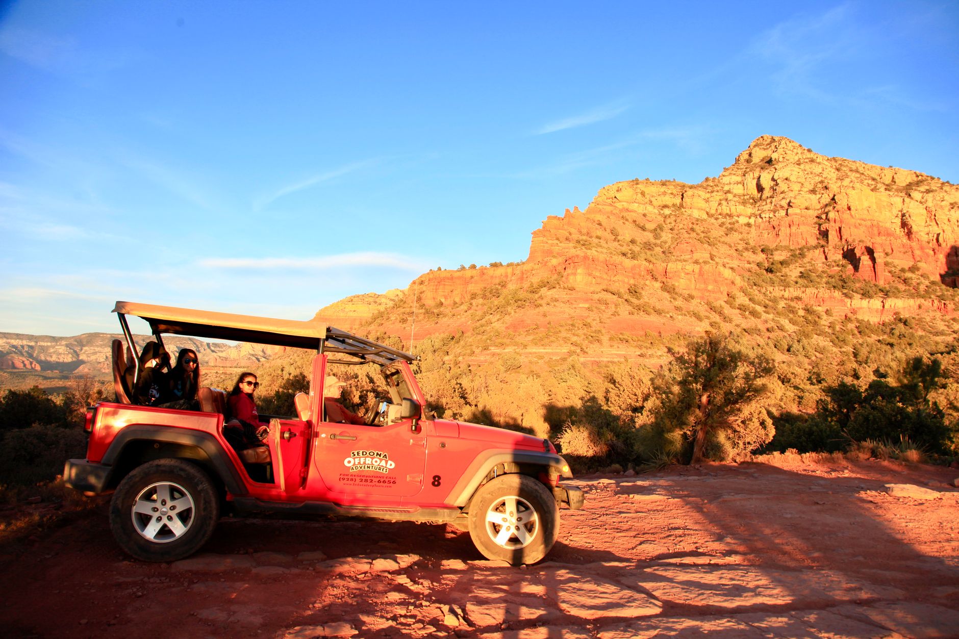 An open-air tour vehicle on the canyon floor, guided access required beyond the rim.
