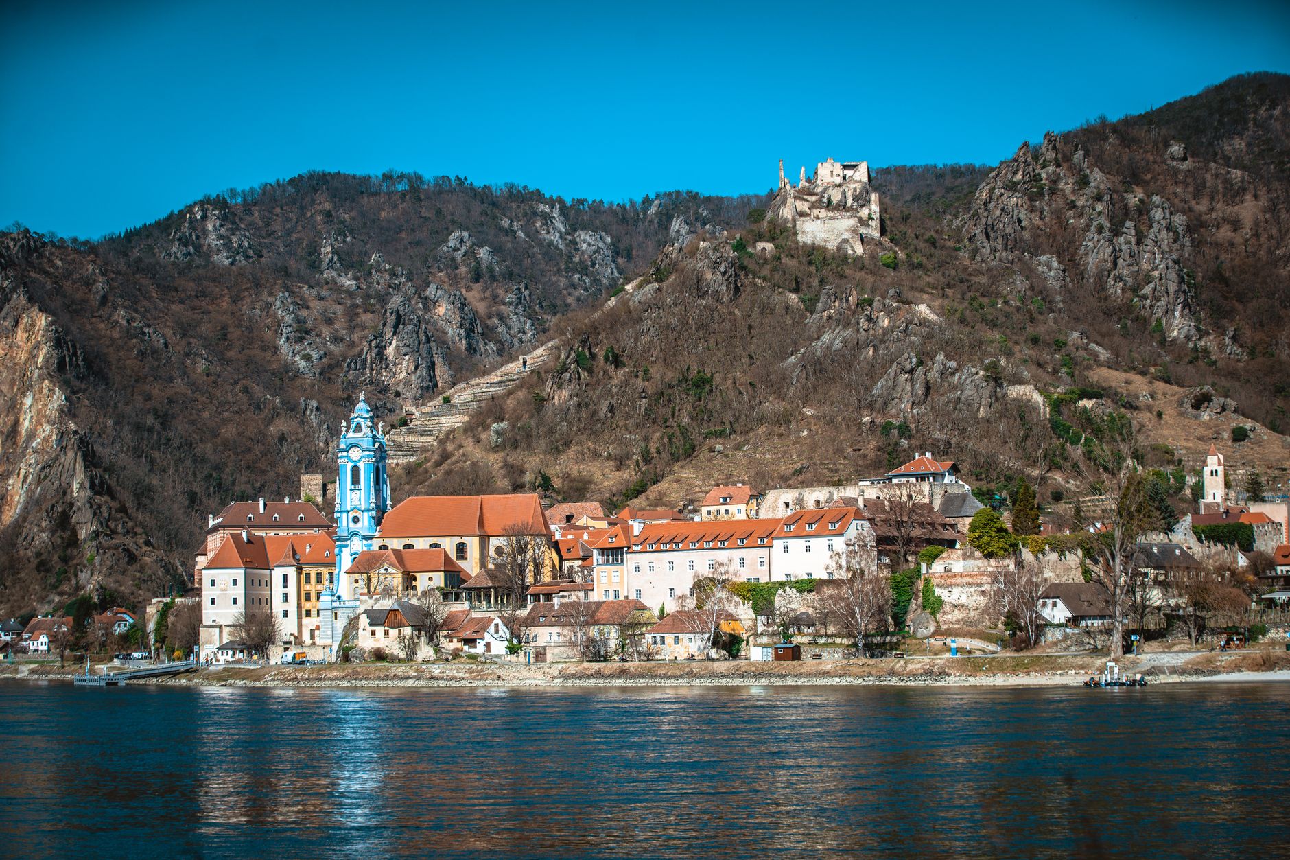 Blue and white baroque church tower rising above the Wachau Valley village of Dürnstein on the Danube River