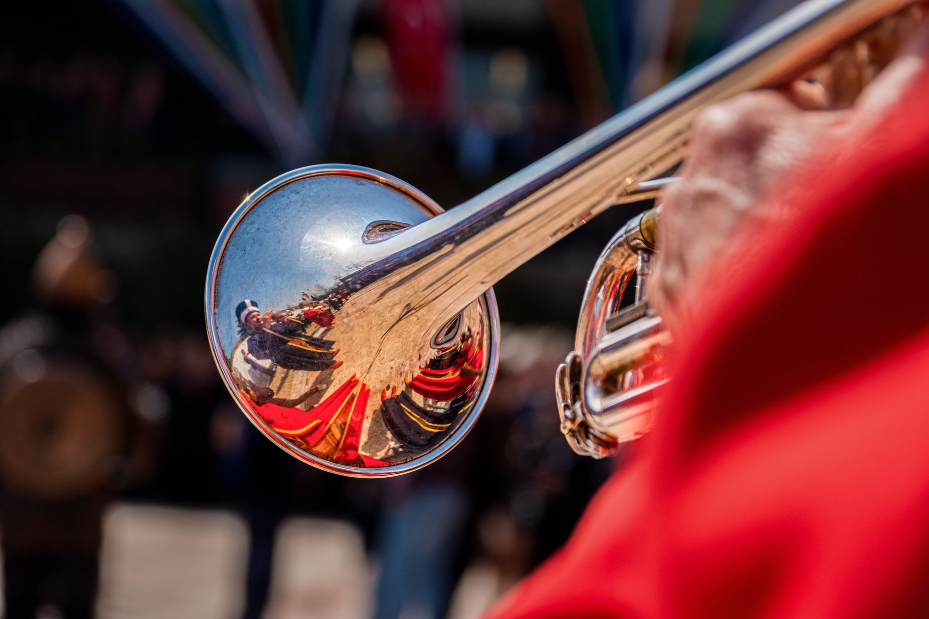 Brass musicians marching through a crowded village square in Guča, Serbia