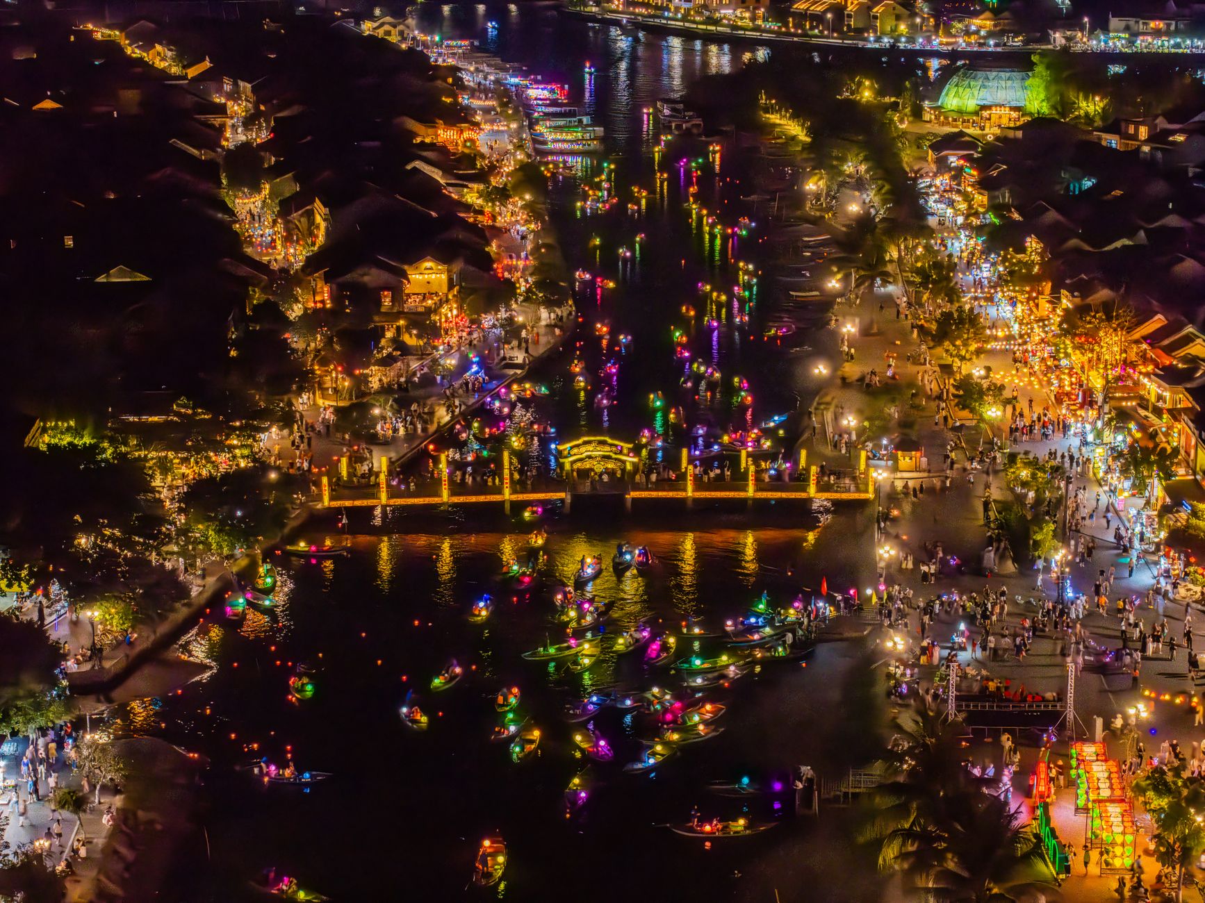 Colorful lanterns reflecting on the Thu Bon River in Hoi An at dusk