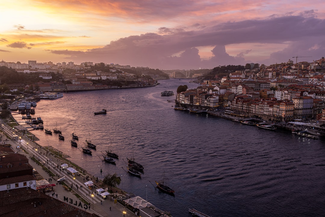 Colorful riverfront houses in Porto's Ribeira district beneath the double-deck Dom Luís I Bridge over the Douro River