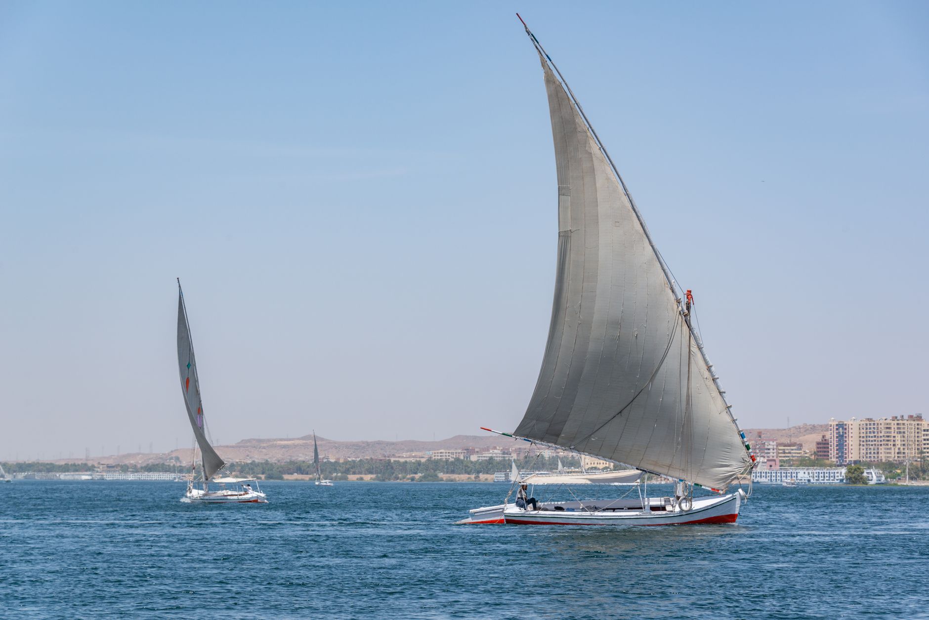 Crew raising the lateen sail as the wind picks up mid-morning.