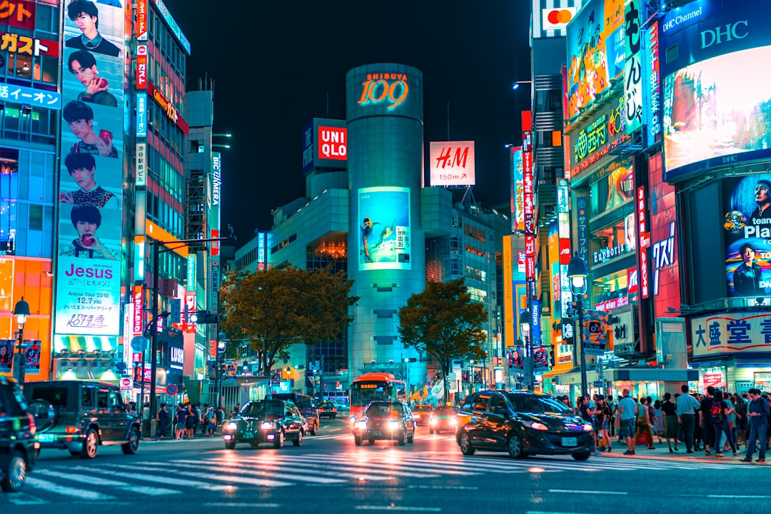 Crowds crossing Shibuya Crossing in Tokyo at night with illuminated signage