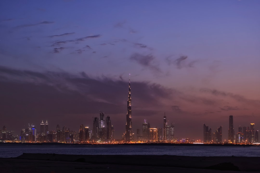 Dubai skyline at dusk with the Burj Khalifa rising above the city and desert beyond