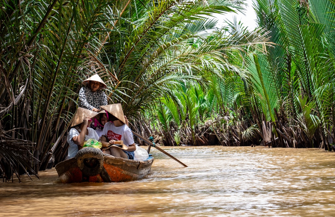 Fruit boats gather at Cai Be's floating market before 8am, each hanging a sample of its cargo from a bamboo pole.