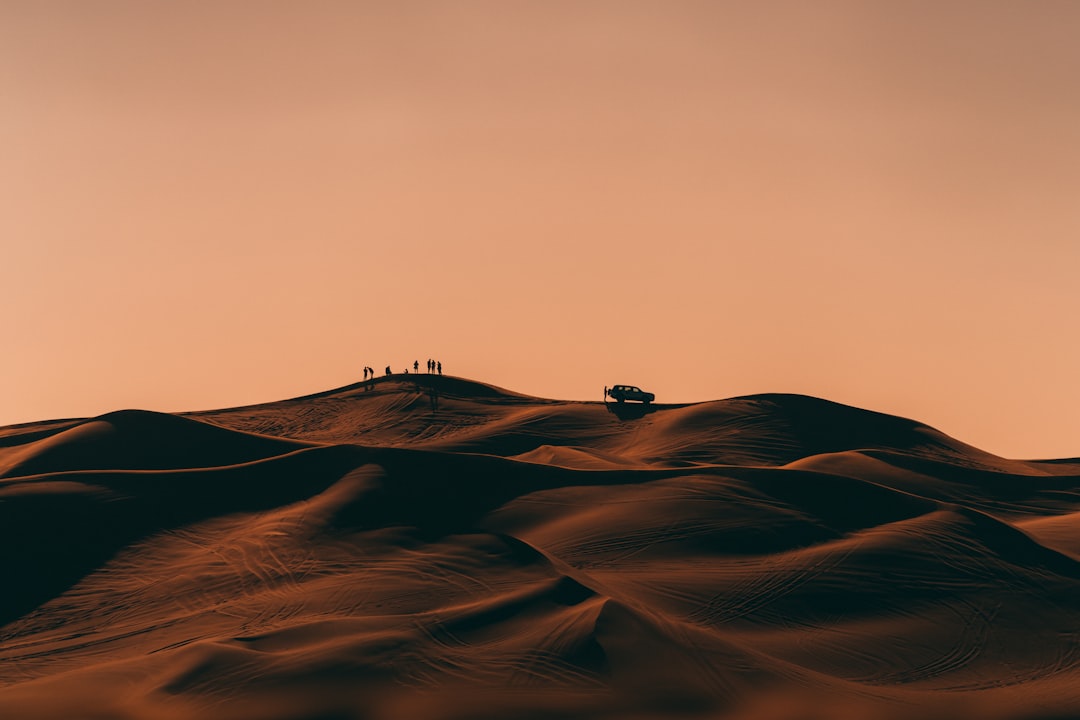 Golden sand dunes under clear sky at sunrise