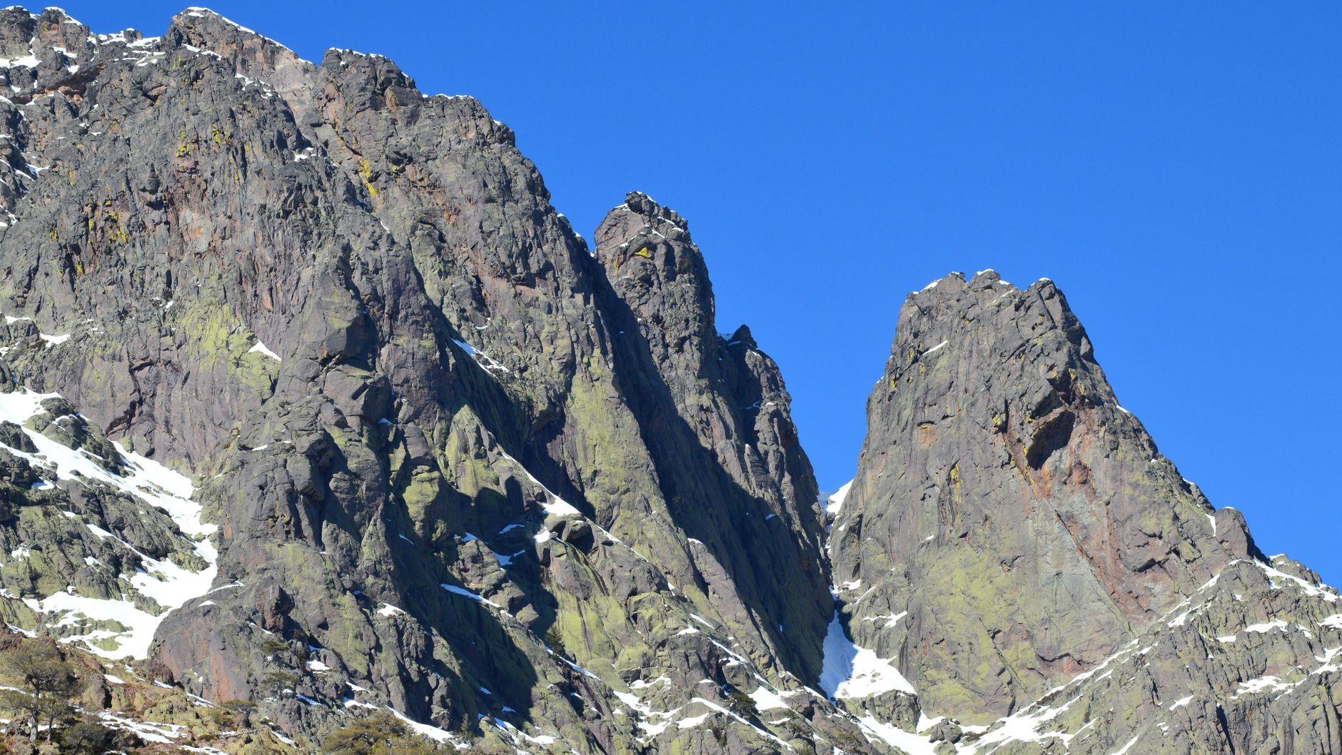 Hikers climb toward the Mirador Francés overlook, with the Cuernos massif rising on the far side of the valley.
