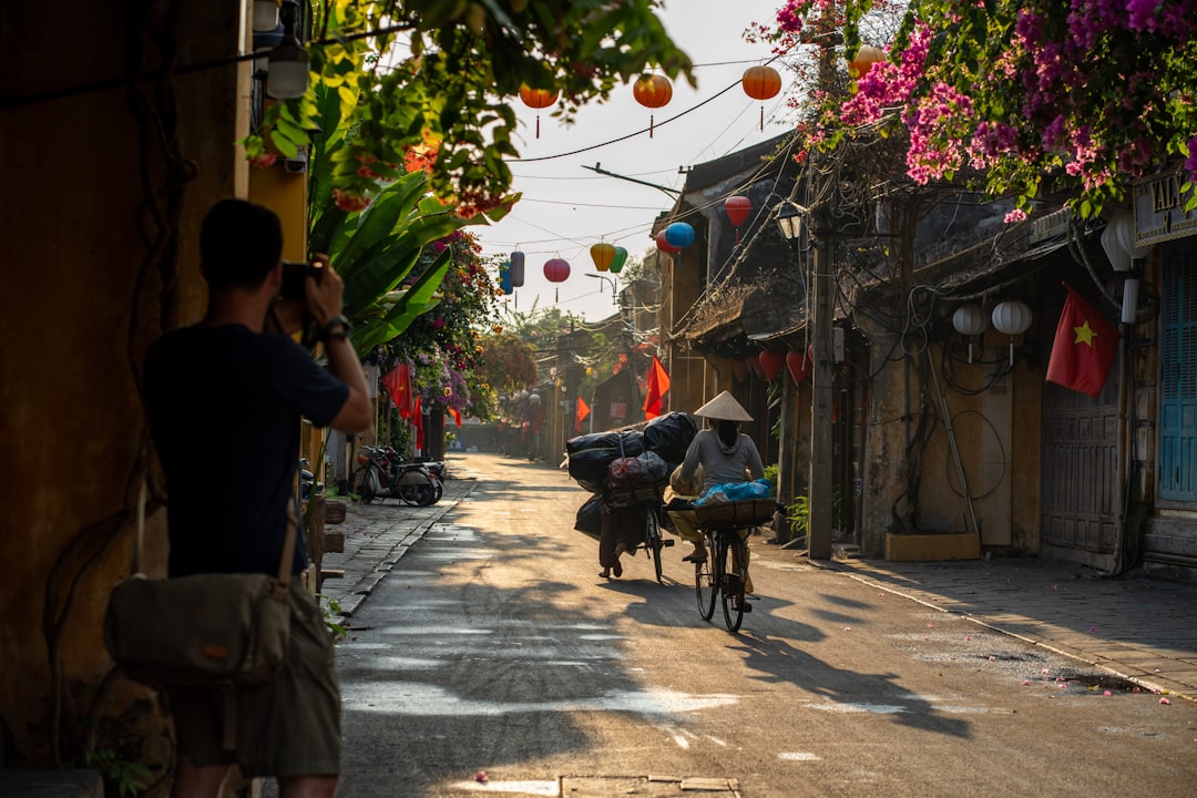 Lantern-lit streets of Hoi An Old Town with mustard-yellow buildings reflected in water