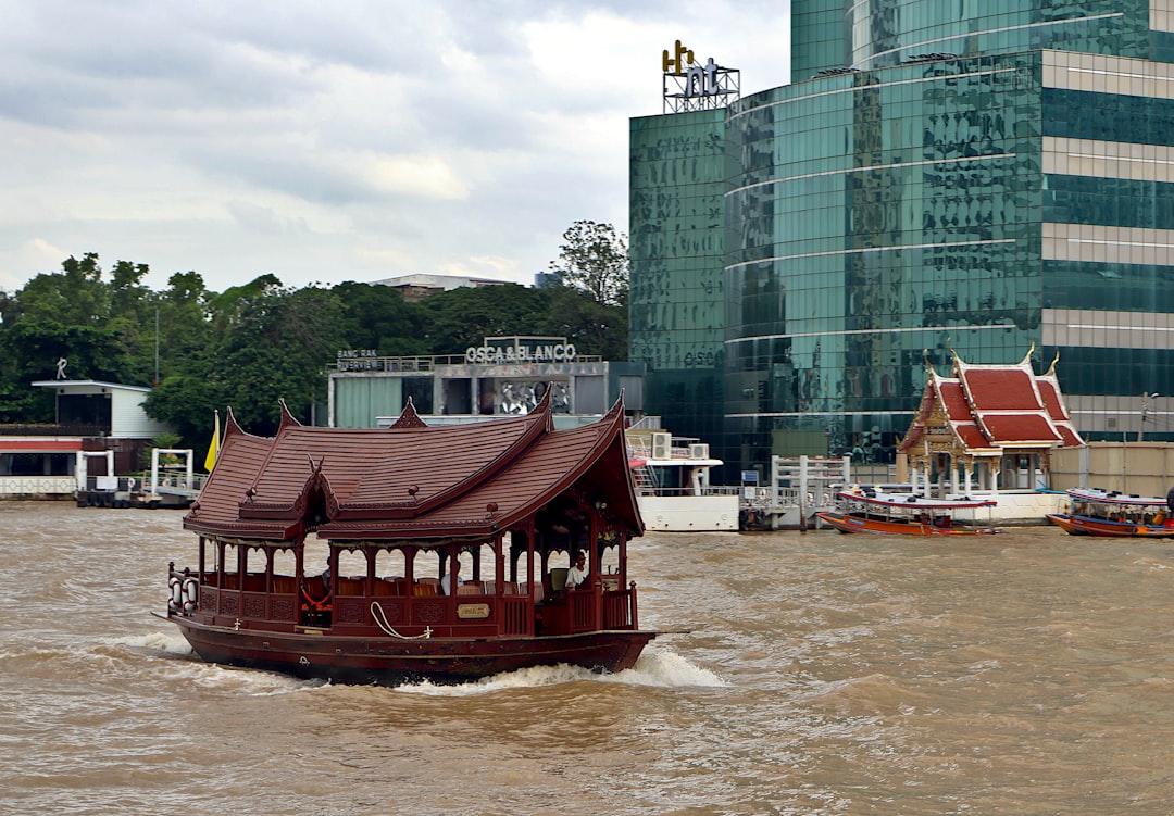 Longtail boats on the Chao Phraya River in Bangkok at sunset with the city skyline behind