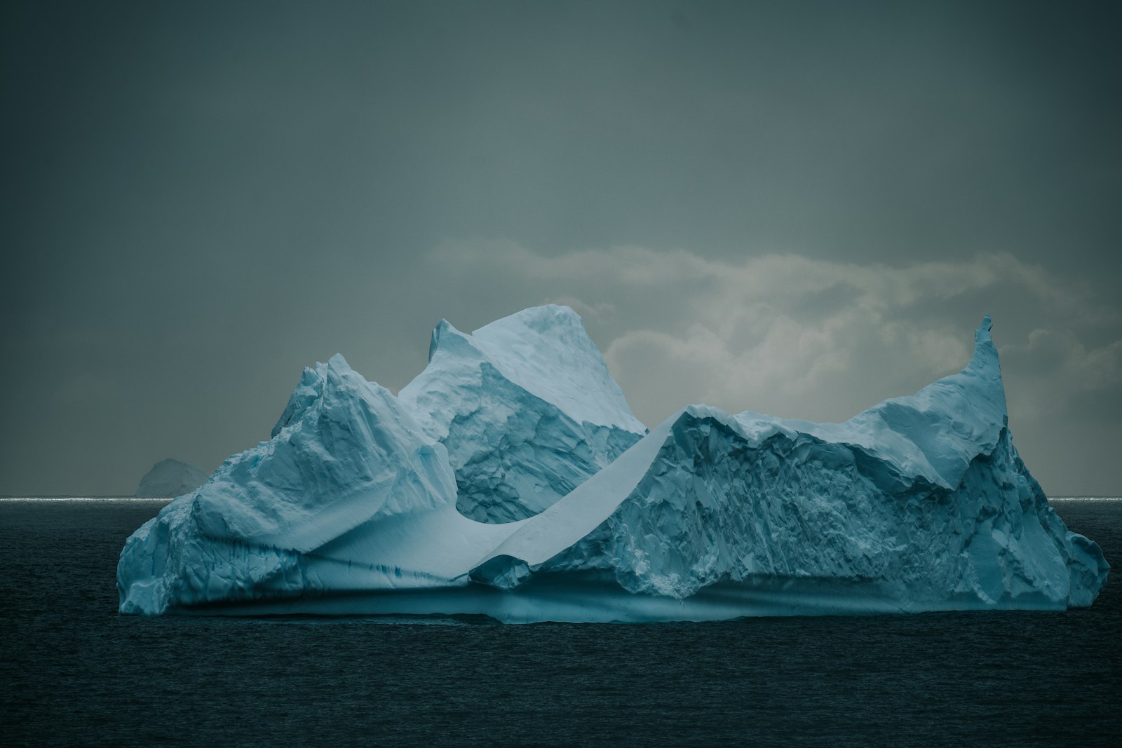 Luxury expedition ship threading the narrow, cliff-lined Lemaire Channel in Antarctica