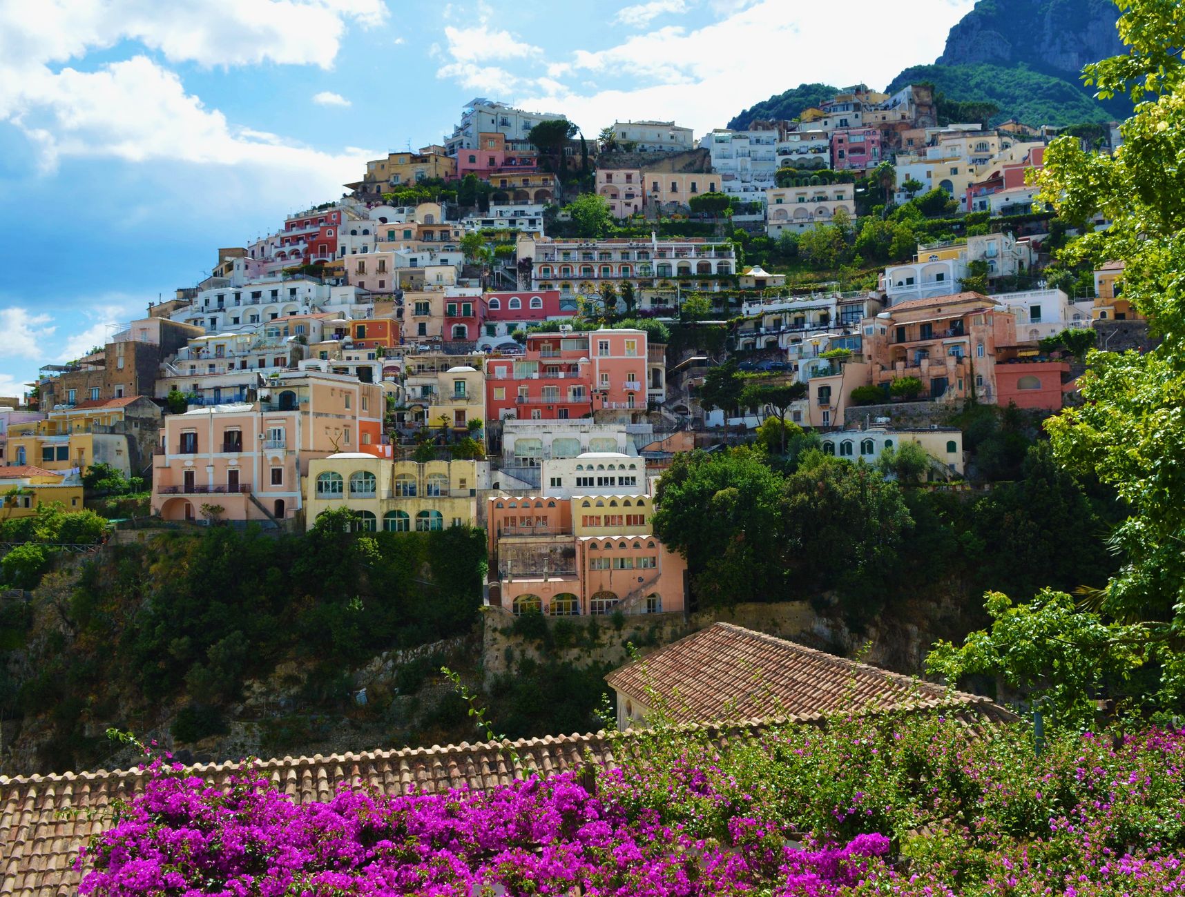 Pastel-colored houses of Positano cascading down a cliff to the sea