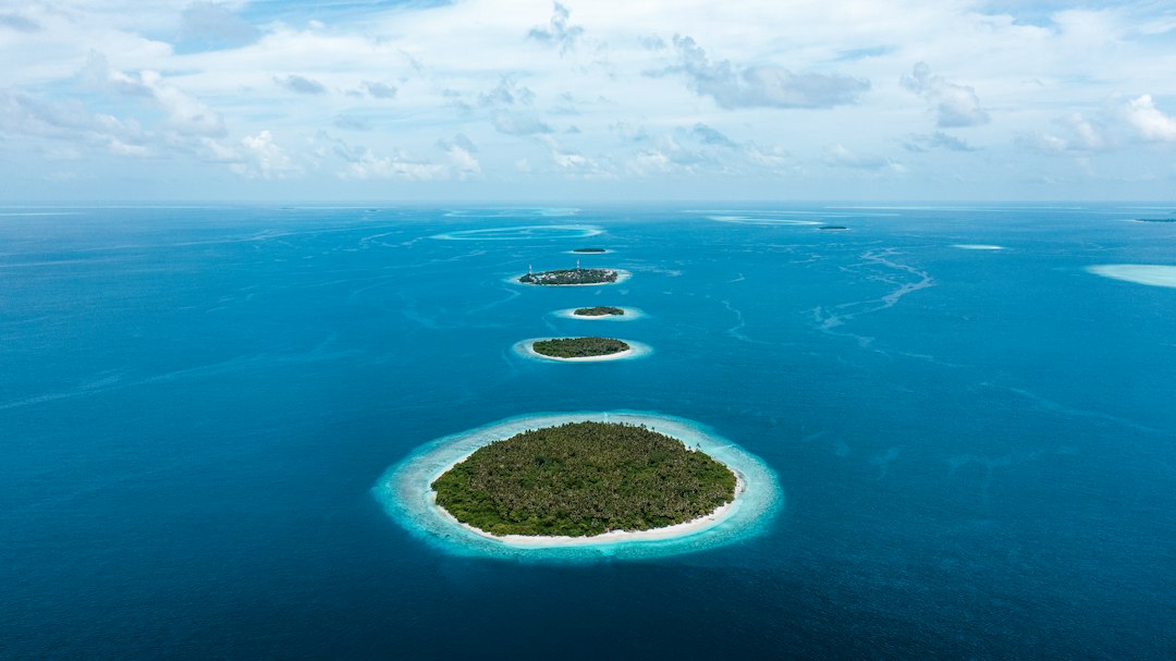 Seaplane flying low over turquoise reef lagoons in Baa Atoll, Maldives