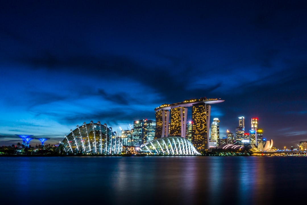 Singapore skyline at night with Marina Bay Sands and reflected lights on water
