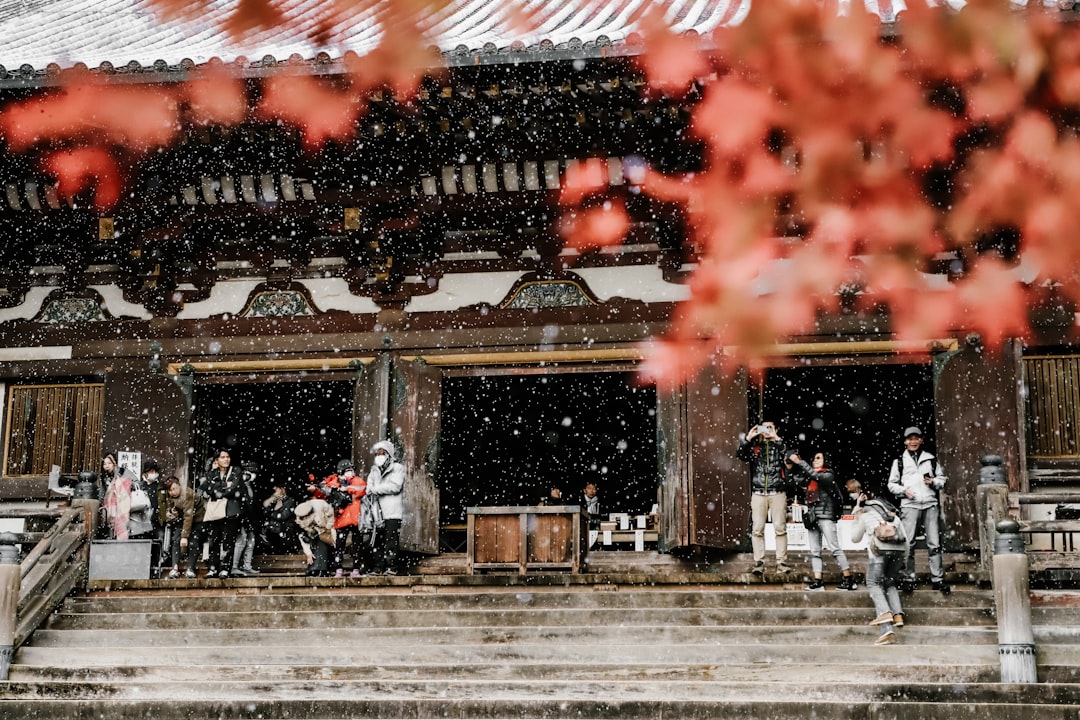 Snow-dusted traditional Japanese temple in Kyoto with bare winter branches