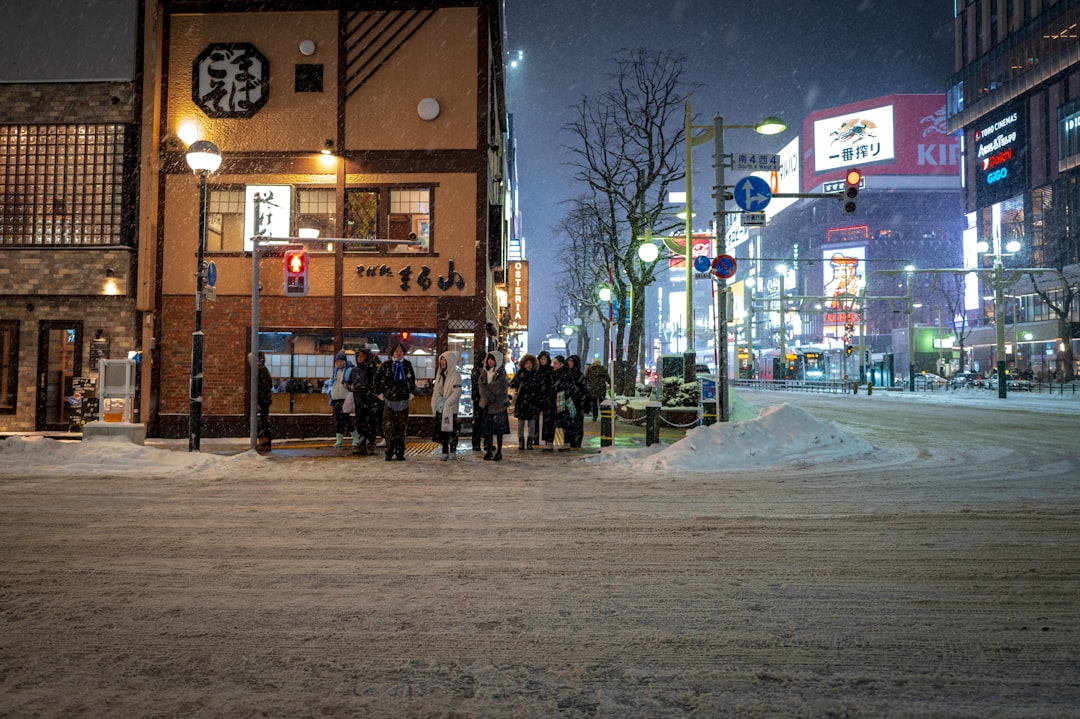 Snowy Sapporo street at night with a lit ramen shop
