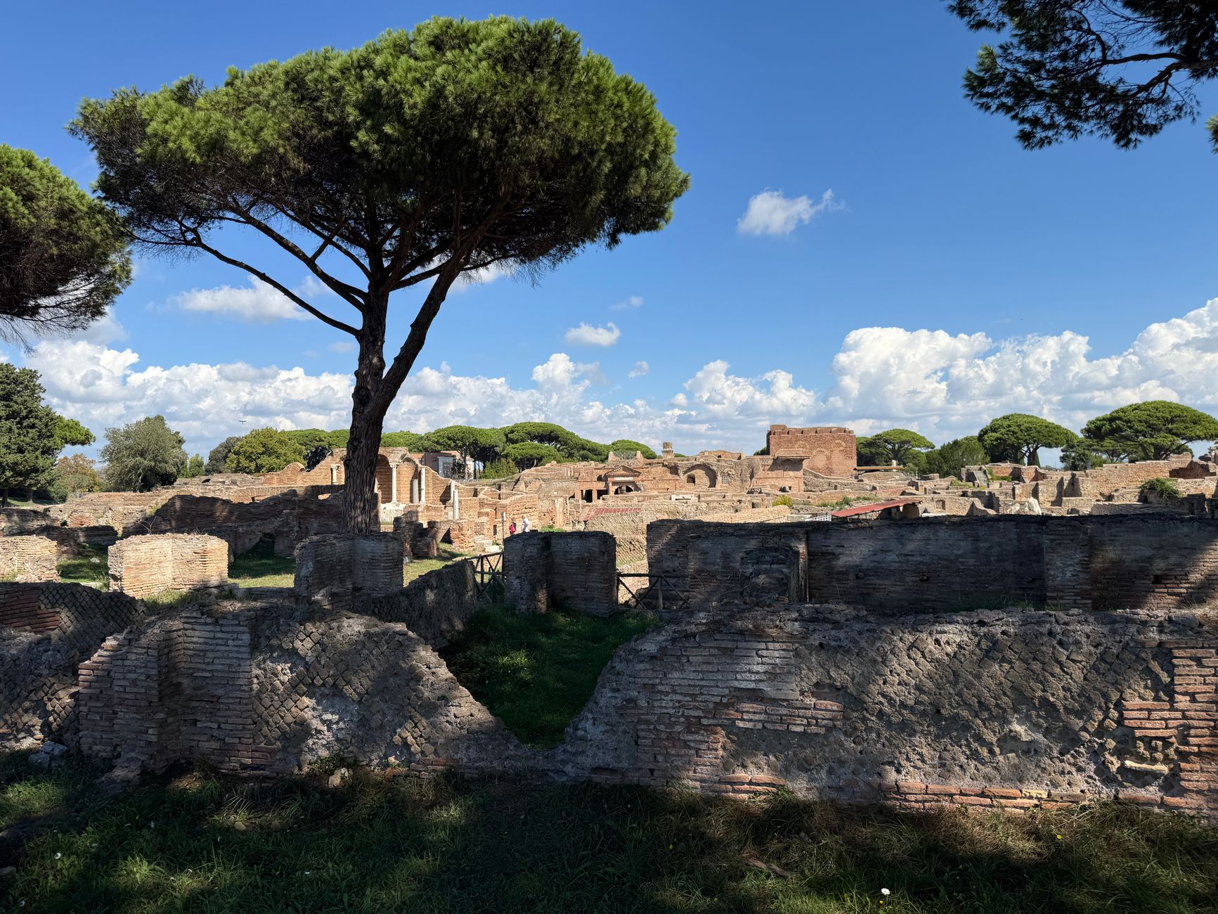 Stone-paved ancient Roman road lined with brick ruins at Ostia Antica