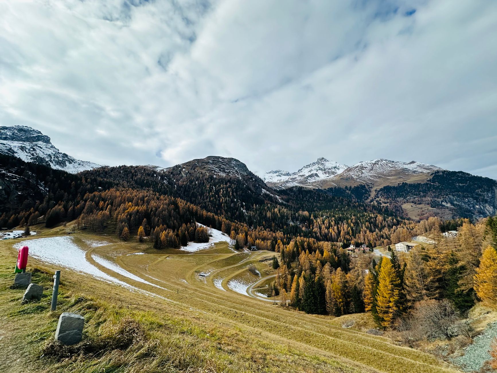 Swiss Alps valley with early snow on peaks and golden larch forests