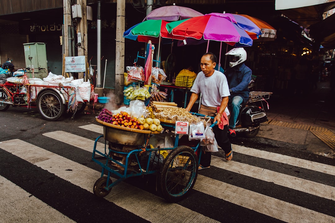 Thai market vendor with fresh mango and tropical fruit displays