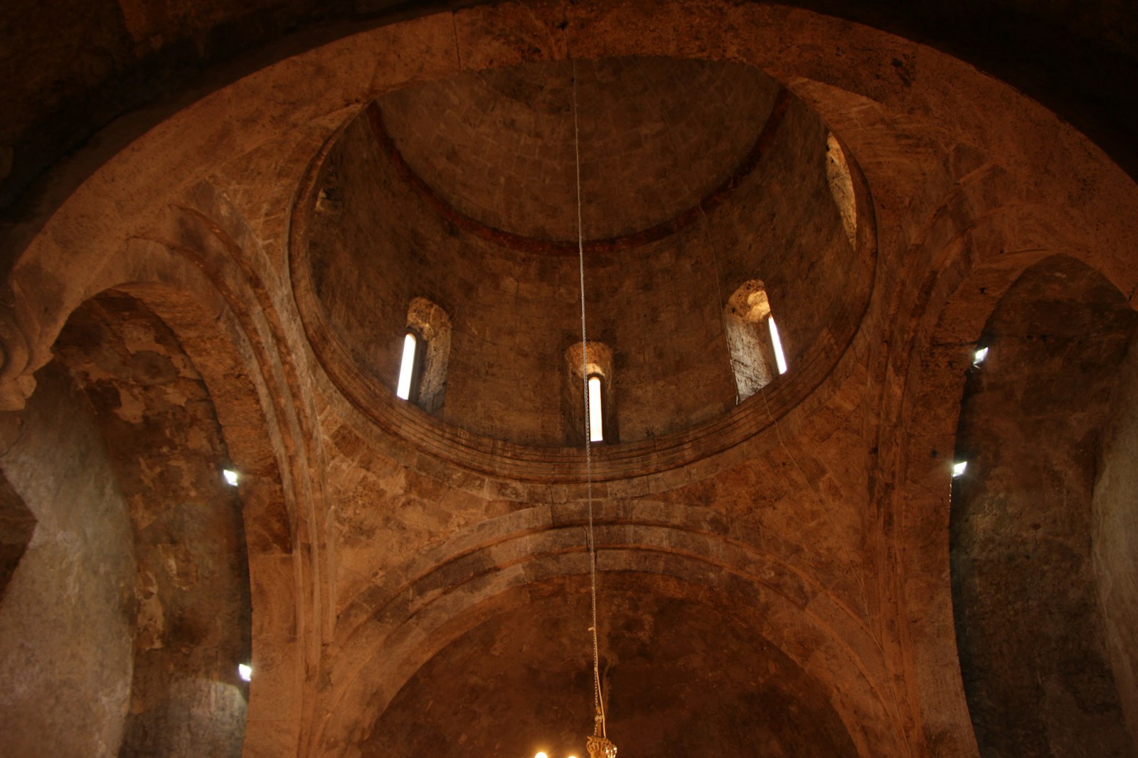 The candlelit interior of Yemrehana Krestos, a wood-and-stone church built inside a limestone cave.