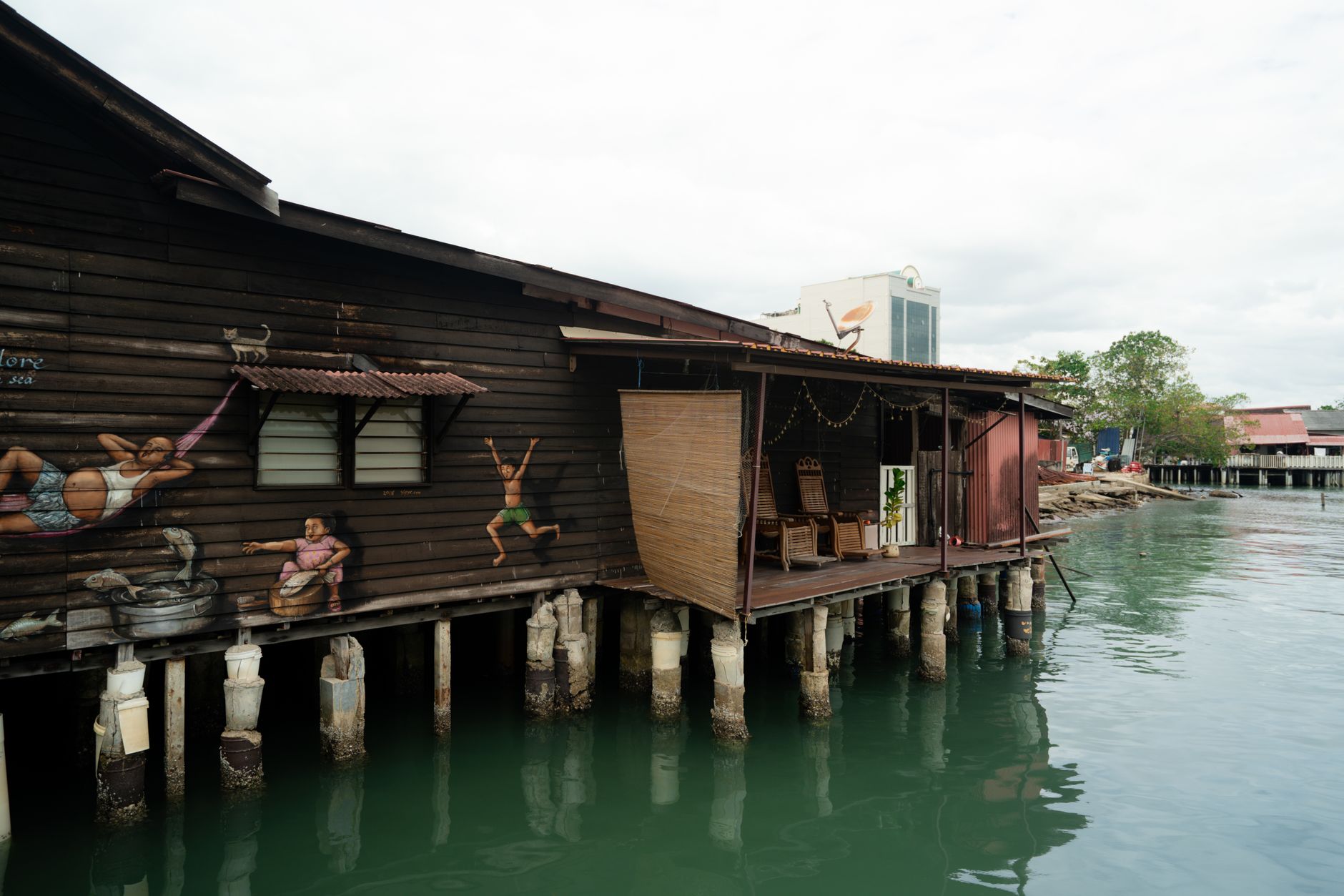 The stilted wooden shopfronts of Ban Si Raya, Koh Lanta's Old Town, over the eastern tidal channel.