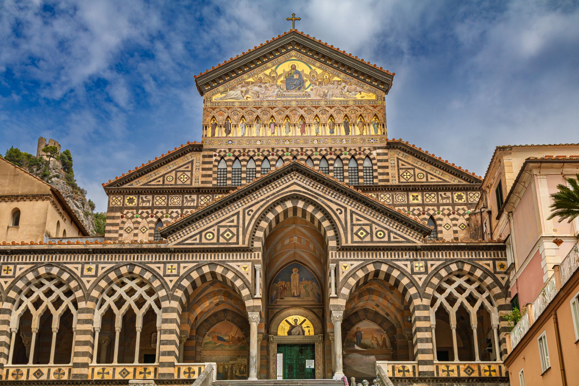 The striped facade and cloistered courtyard of Amalfi's Duomo di Sant'Andrea, above the town's main piazza.