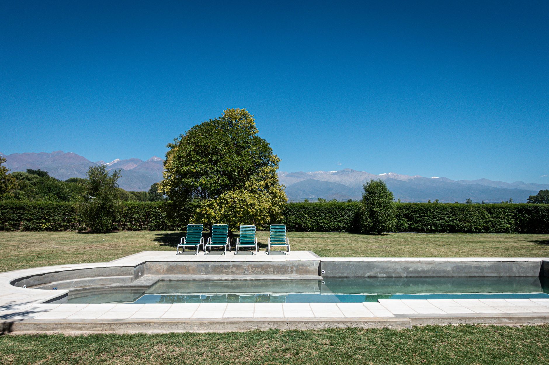 The villa at The Vines Resort & Spa, San Pablo, with its glass wall framing the Andes at dusk.