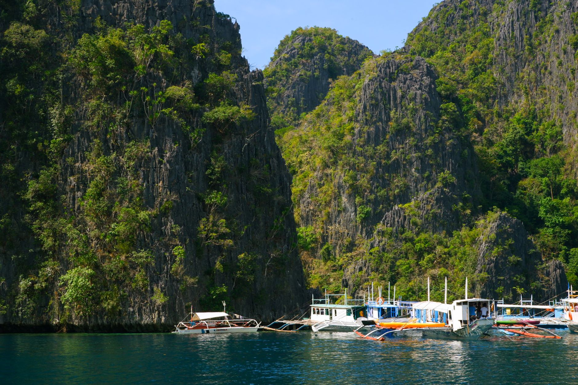 Traditional outrigger boats anchor in calm waters during spring, offering intimate access to shallow reefs and small islands.