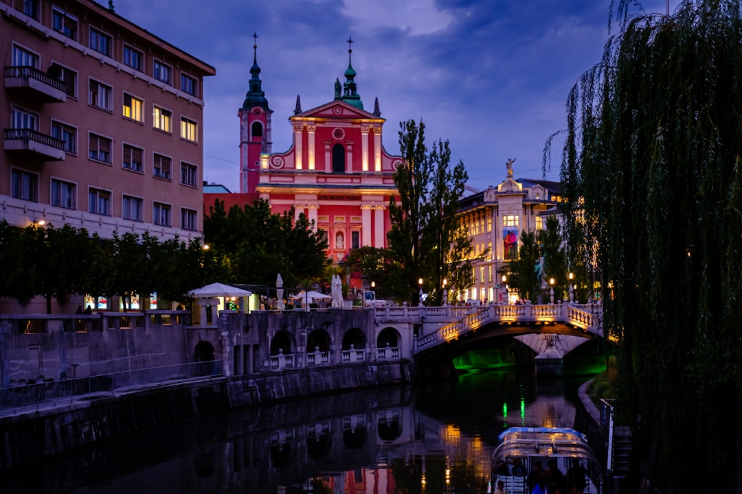 View across the Ljubljanica River toward Ljubljana Castle at dusk