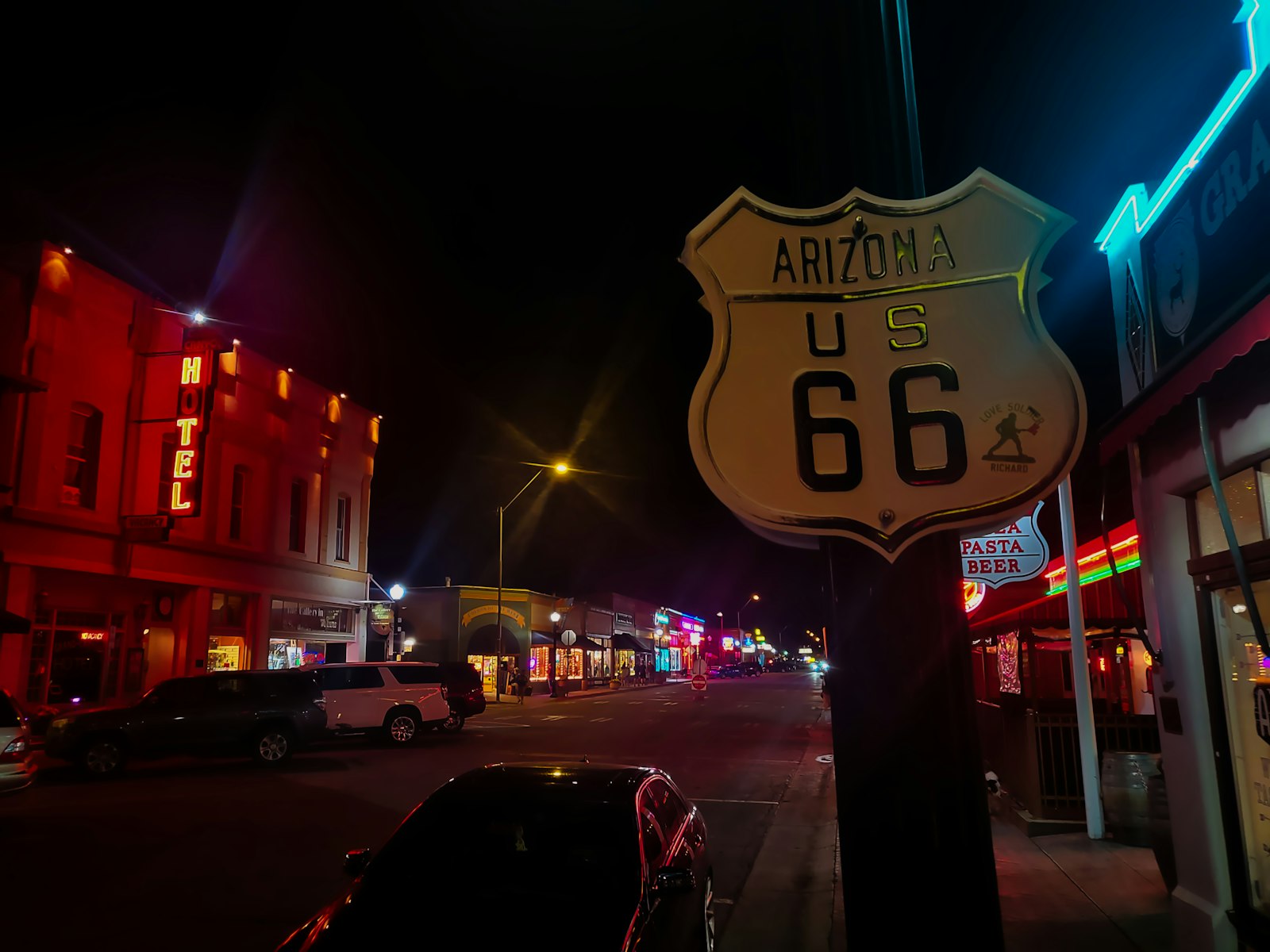 Vintage Route 66 neon sign glowing against a desert sky in Seligman, Arizona