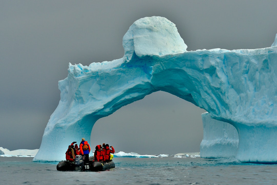 Zodiac boat with expedition passengers navigating icebergs off the Antarctic Peninsula